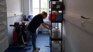 Putzfrau räumt die Reinigungskammer auf und sortiert prüft die Reinigungschemie