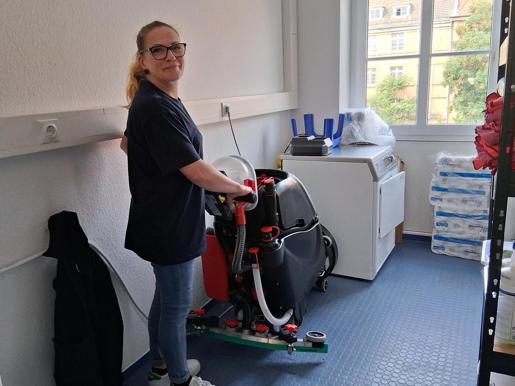 Putzfrau räumt die Reinigungskammer auf und sortiert prüft die Reinigungsmaschine