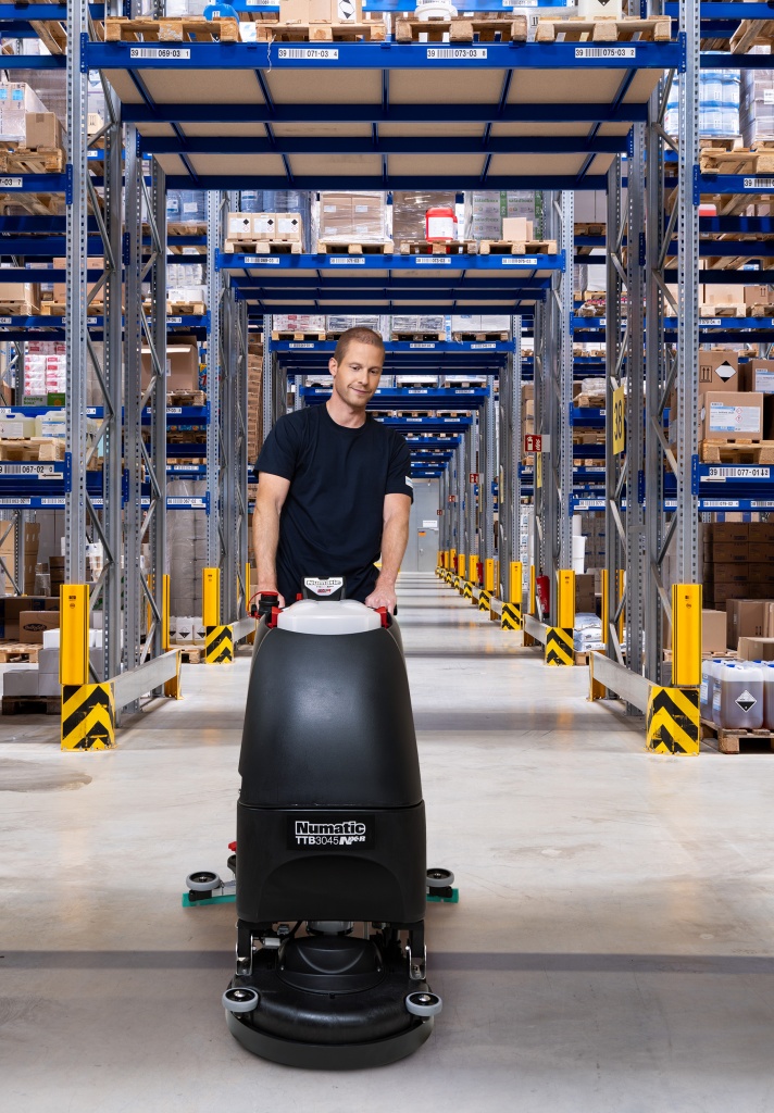 Mitarbeiter des RWS Gebäudeservice reinigt mit einer Maschine die Böden eines Hochregallagers.