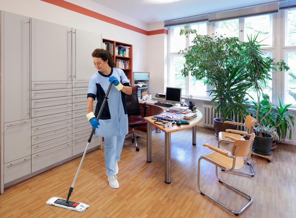 RWS Gebäudeservice Mitarbeiterin wischt Boden in einer Arztpraxis für hygienische Sauberkeit und gepflegtes Ambiente.