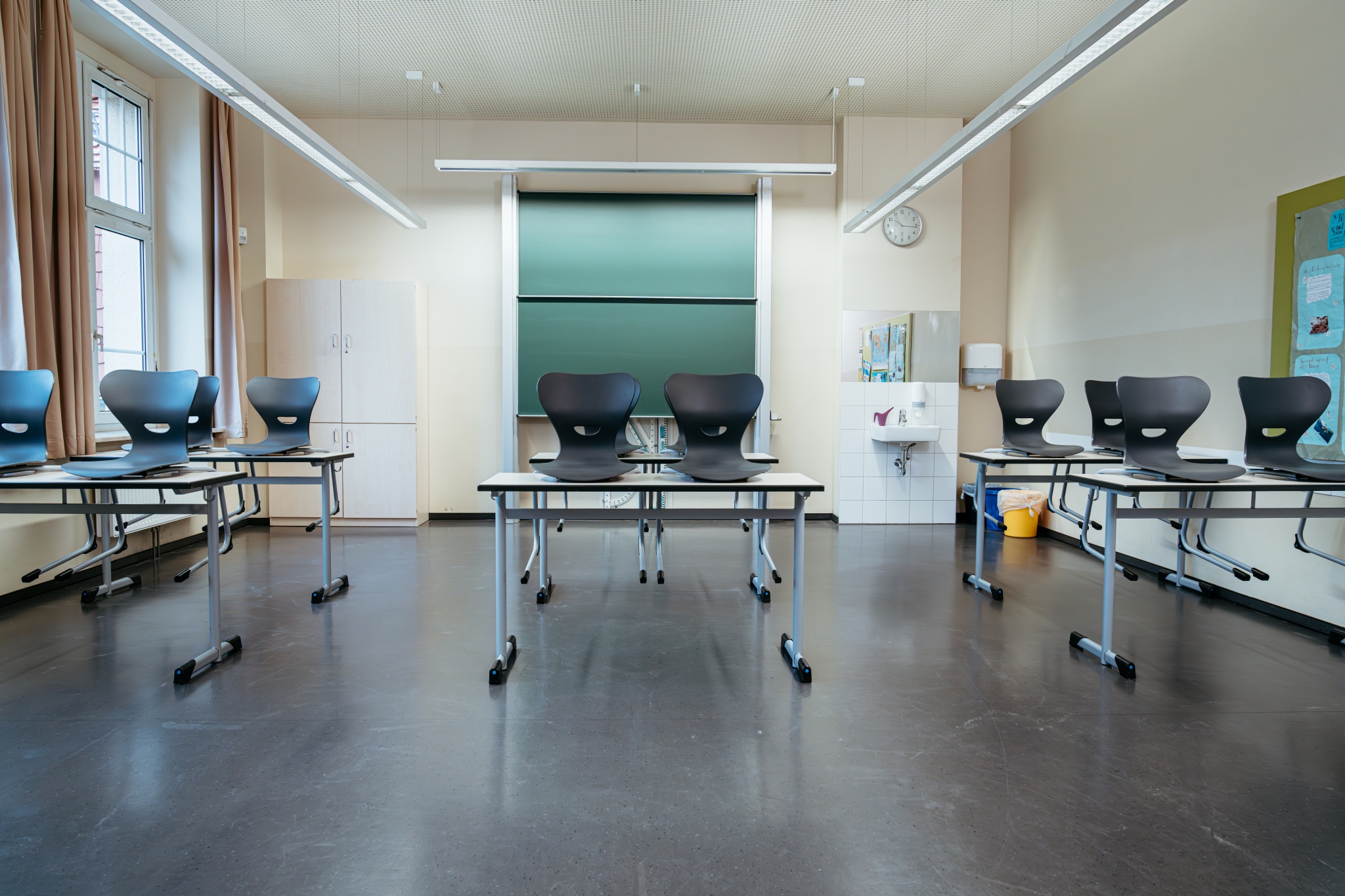 Aufgeräumtes Klassenzimmer mit Tafel, Stühlen und Tischen in einer Schule