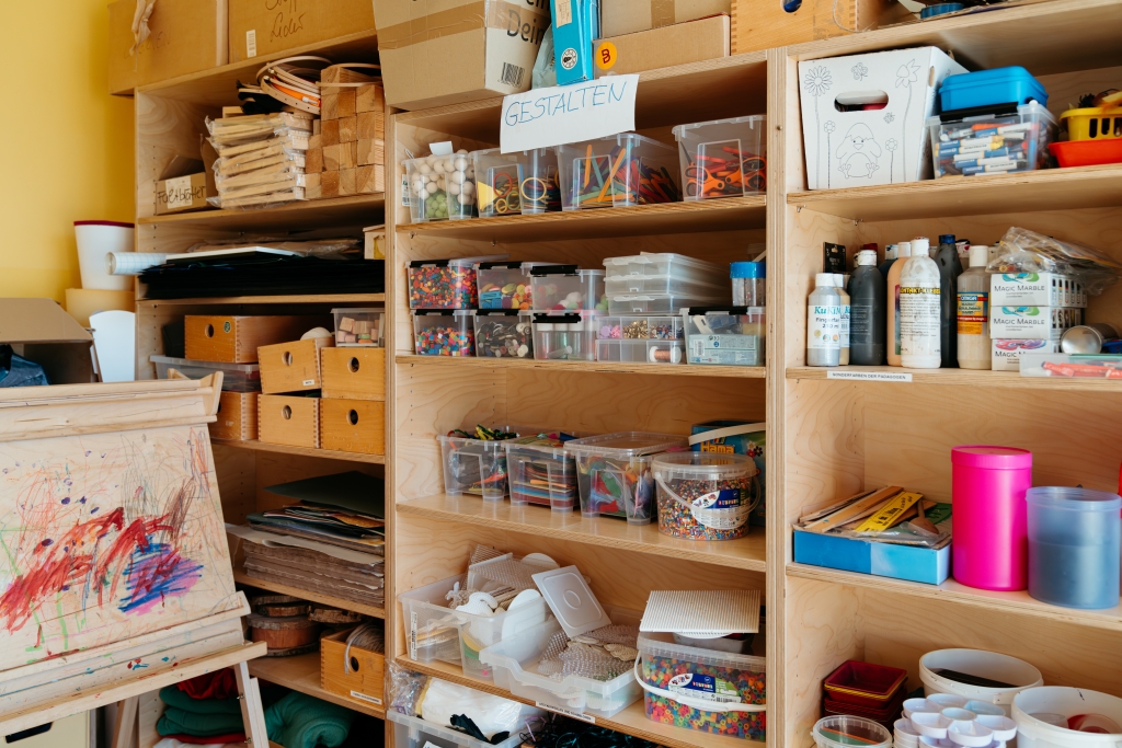 Regal mit Bastelutensilien und Farben in einer Kita