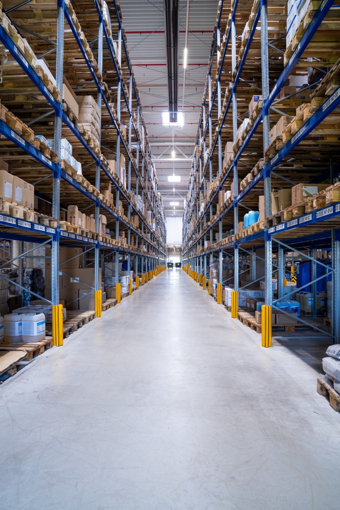 Hochregallager mit langen Regalreihen und einem sauberen, freien Gang für effiziente Logistikprozesse.