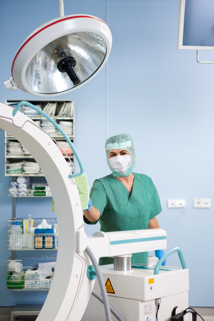 Mitarbeiterin von RWS Gebäudeservice desinfiziert medizinische Geräte im Operationssaal für höchste Hygiene.