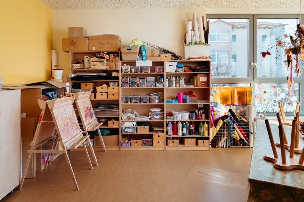 Regal mit Bastelutensilien und Farben in einer Kita