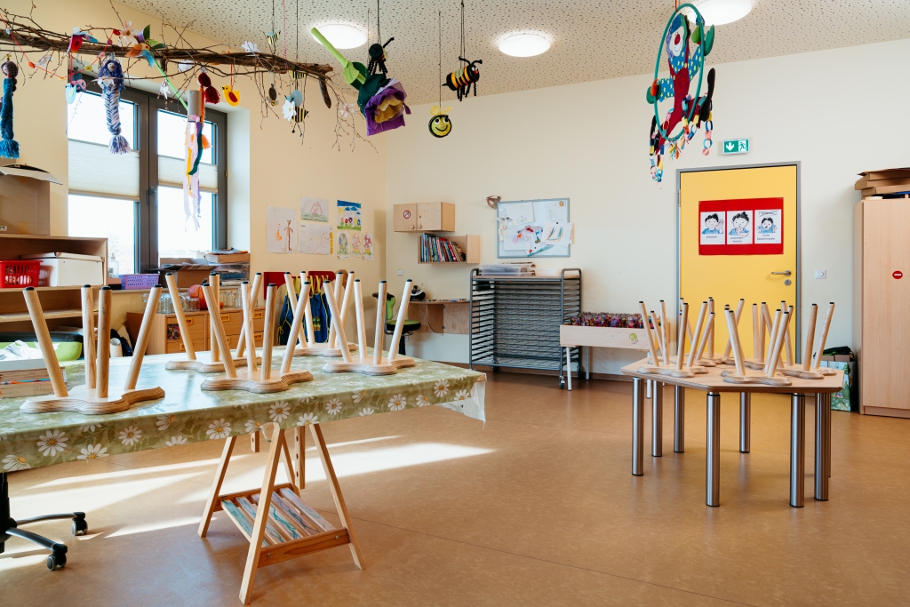 Kita-Atelier mit aufgestellten Stühlen und bunter Raumdekoration