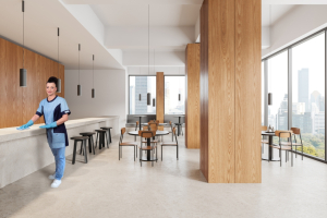 Mitarbeiterin von RWS Gebäudeservice reinigt die Tischoberflächen einer Universitäts-Cafeteria