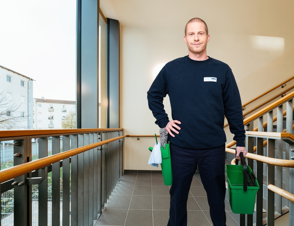 Mitarbeiter von RWS Gebäudeservice reinigt mit professionellem Werkzeug die Fenster einer Schule.