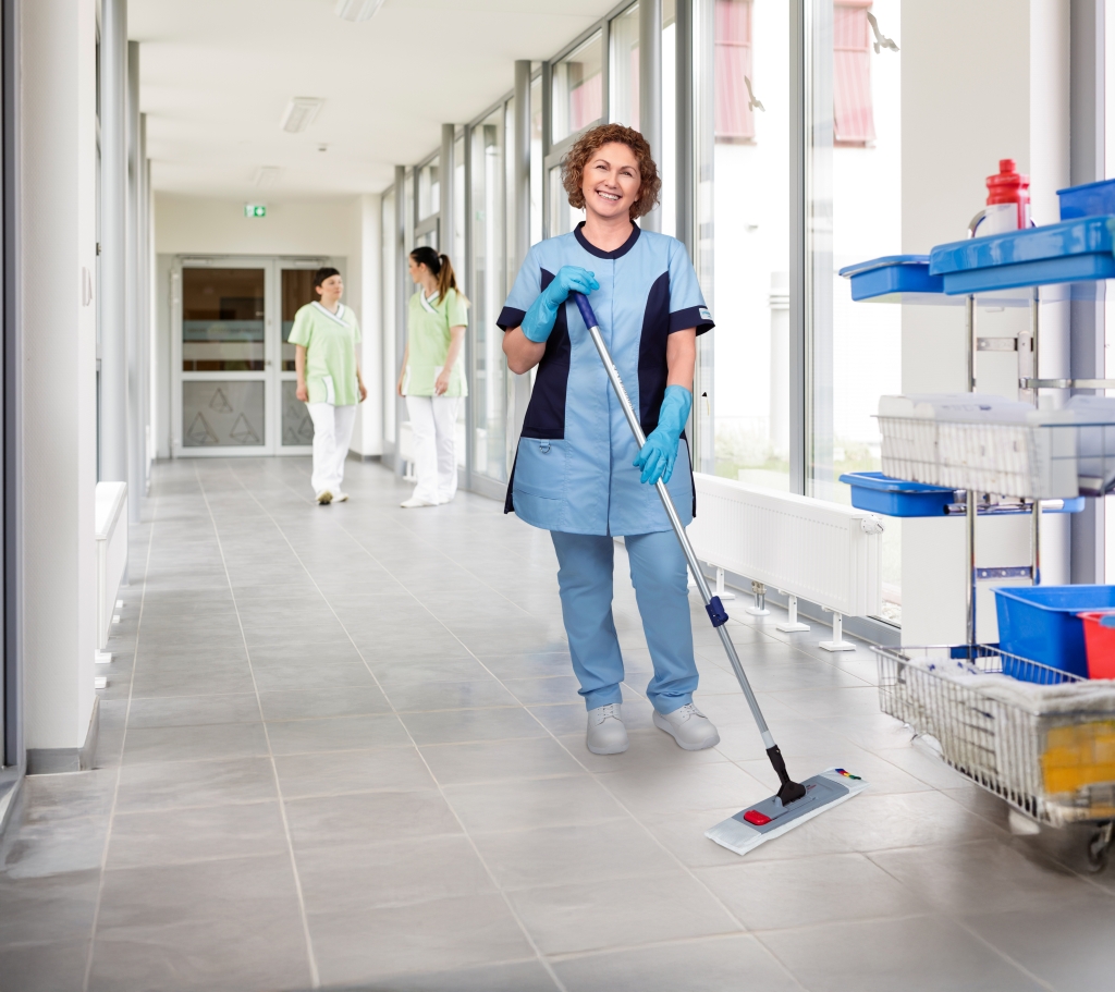 Eine Reinigungskraft von RWS Gebäudeservice wischt den Flur einer Klinik für hygienische Sauberkeit.