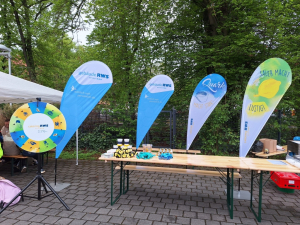 Das Bild zeigt einen Stand mit Glücksrad, kleinen Preisen, RWS Bienen und Honig beim Thepra Aktionstag