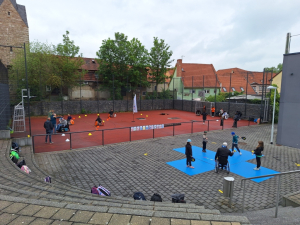 Das Bild zeigt Kinder und betreuer bei Sportstationen im Außenbereich der Halle vom Thepra Aktionstag